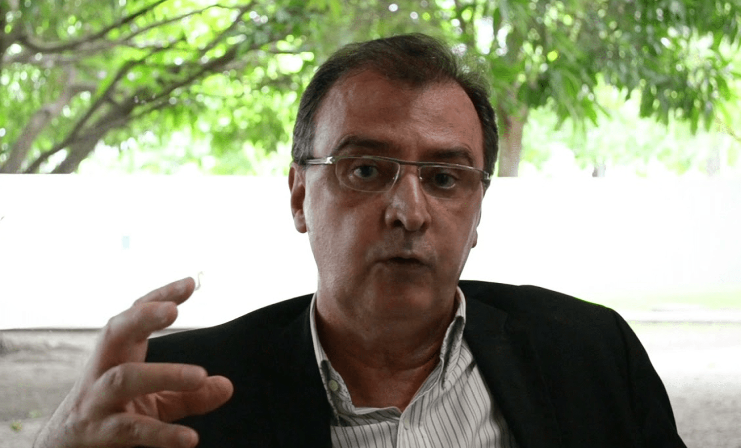 Head Institucional da EqualWeb debate a importância da DEI nas empresas, gestualizando durante a conversa ao ar livre.