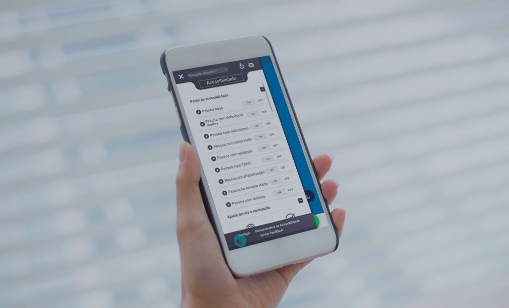 Mão com smartphone: menu de acessibilidade aberto, mostrando opções como cegueira, deficiência motora e TDAH para personalizar a interface.