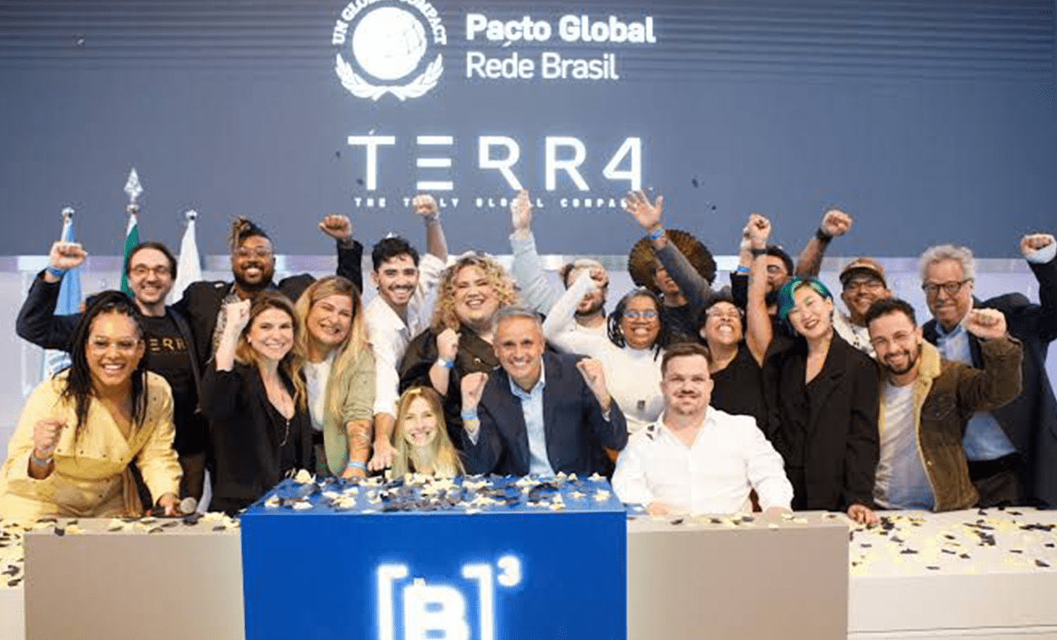 Grupo celebra lançamento da iniciativa TERRA na B3, com logotipos do Pacto Global e [B]³ visíveis ao fundo e sobre a mesa.
