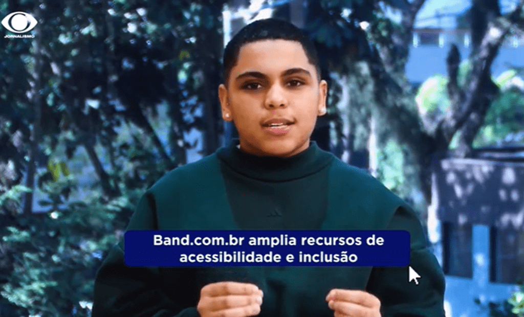 Jovem fala com gestos em vídeo da Band. Legenda informa que o Band.com.br amplia recursos de acessibilidade e inclusão digital.
