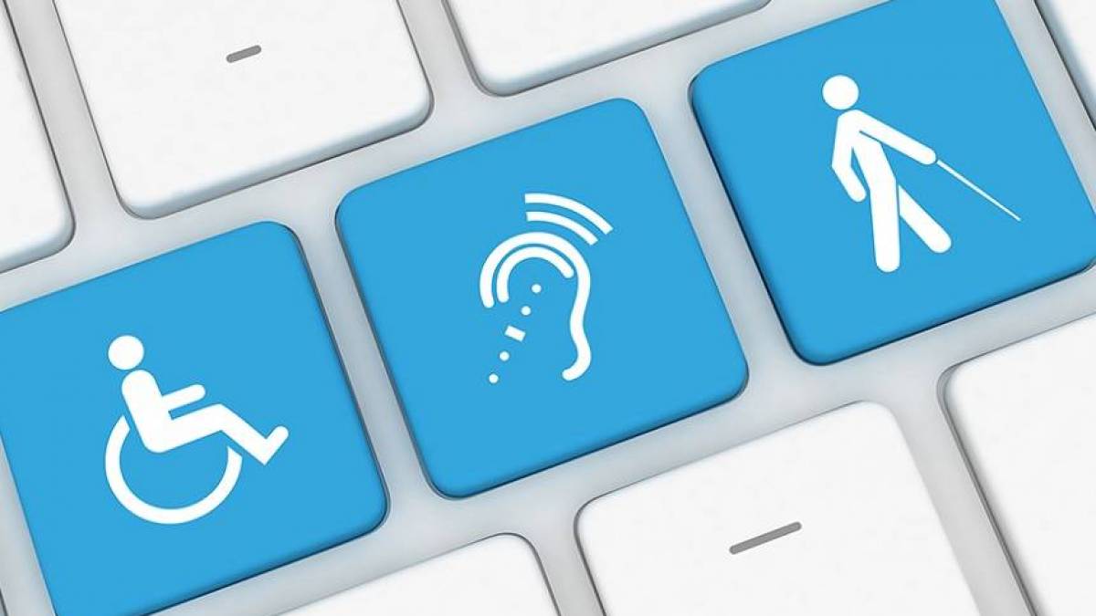 Teclado com teclas azuis exibindo ícones de acessibilidade: cadeira de rodas, ouvido com ondas sonoras e pessoa com bengala.