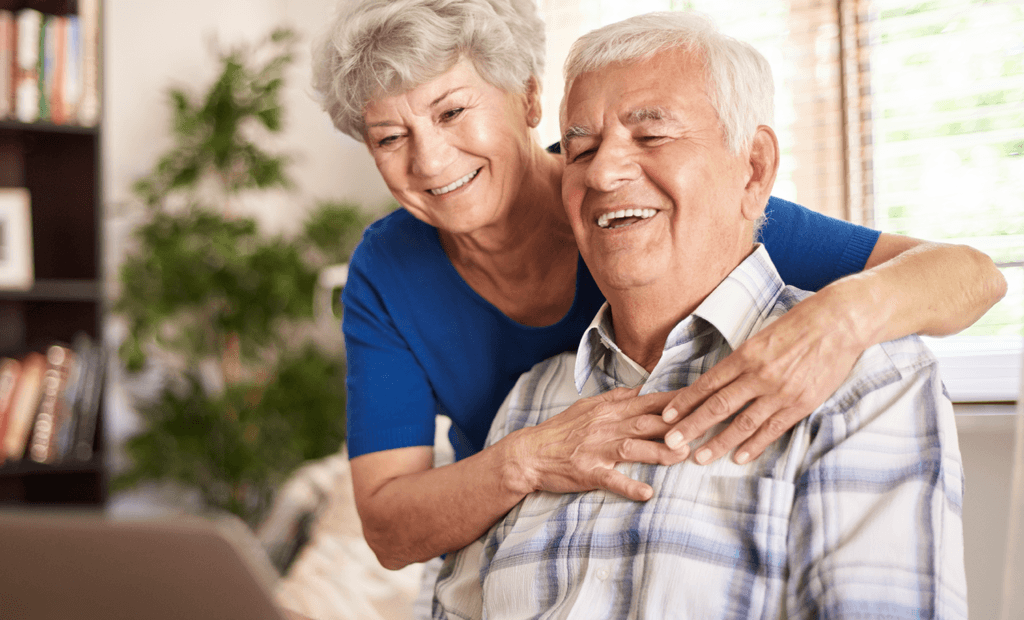 Campanha. Imagem de um casal de idosos de cabelos brancos se abraçando.