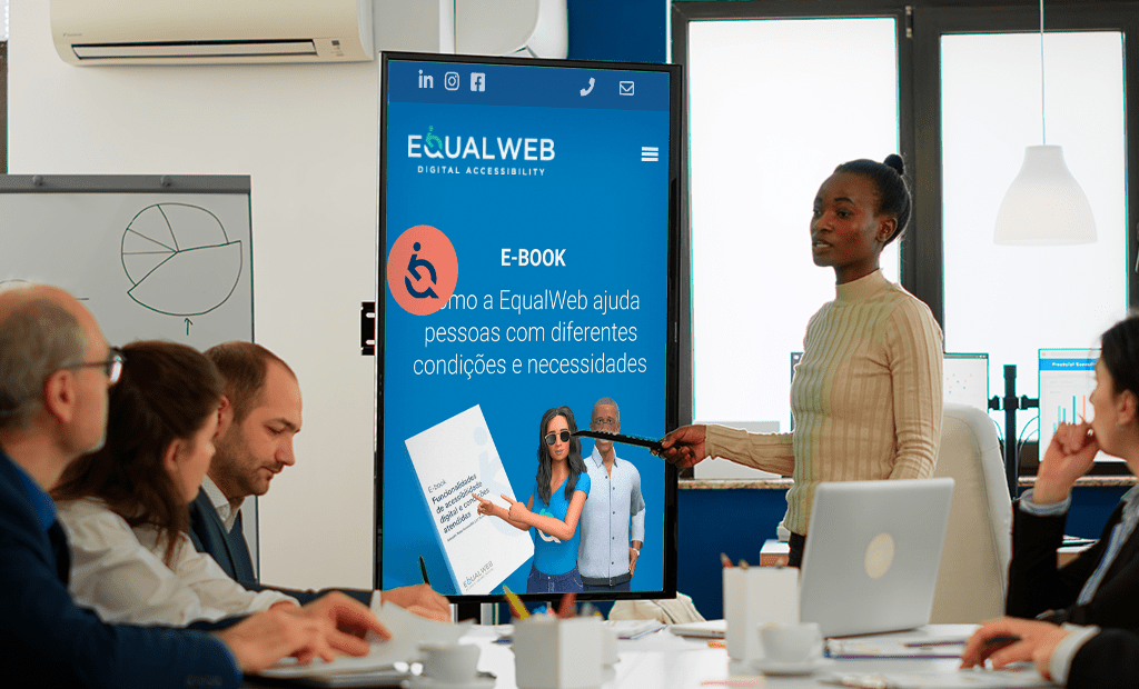 Empresa. Imagem de uma sala de reunião com algumas pessoas e uma moça em foco principal apresentando o site da EqualWeb.