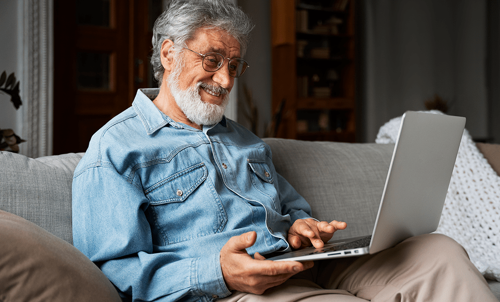 Shoppings. Imagens de um homem aparentando ter mais de 50 anos de barba branca e óculos. Usando um notebook. 